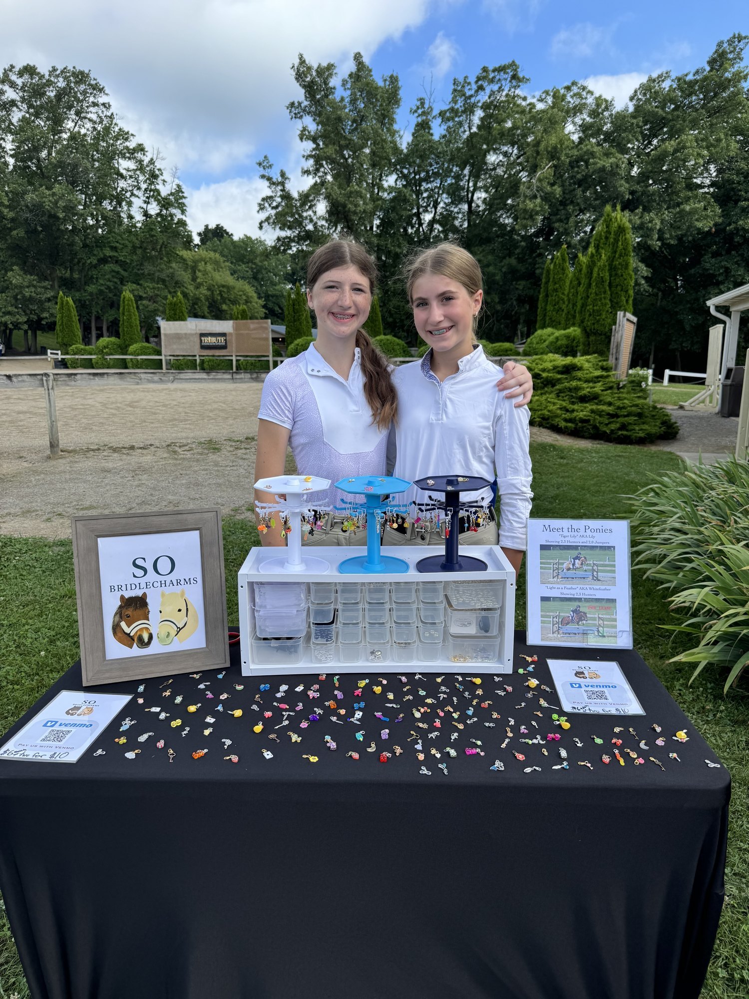 Sadie and Olivia in front of the SO Equestrian booth display at a Michigan horse show