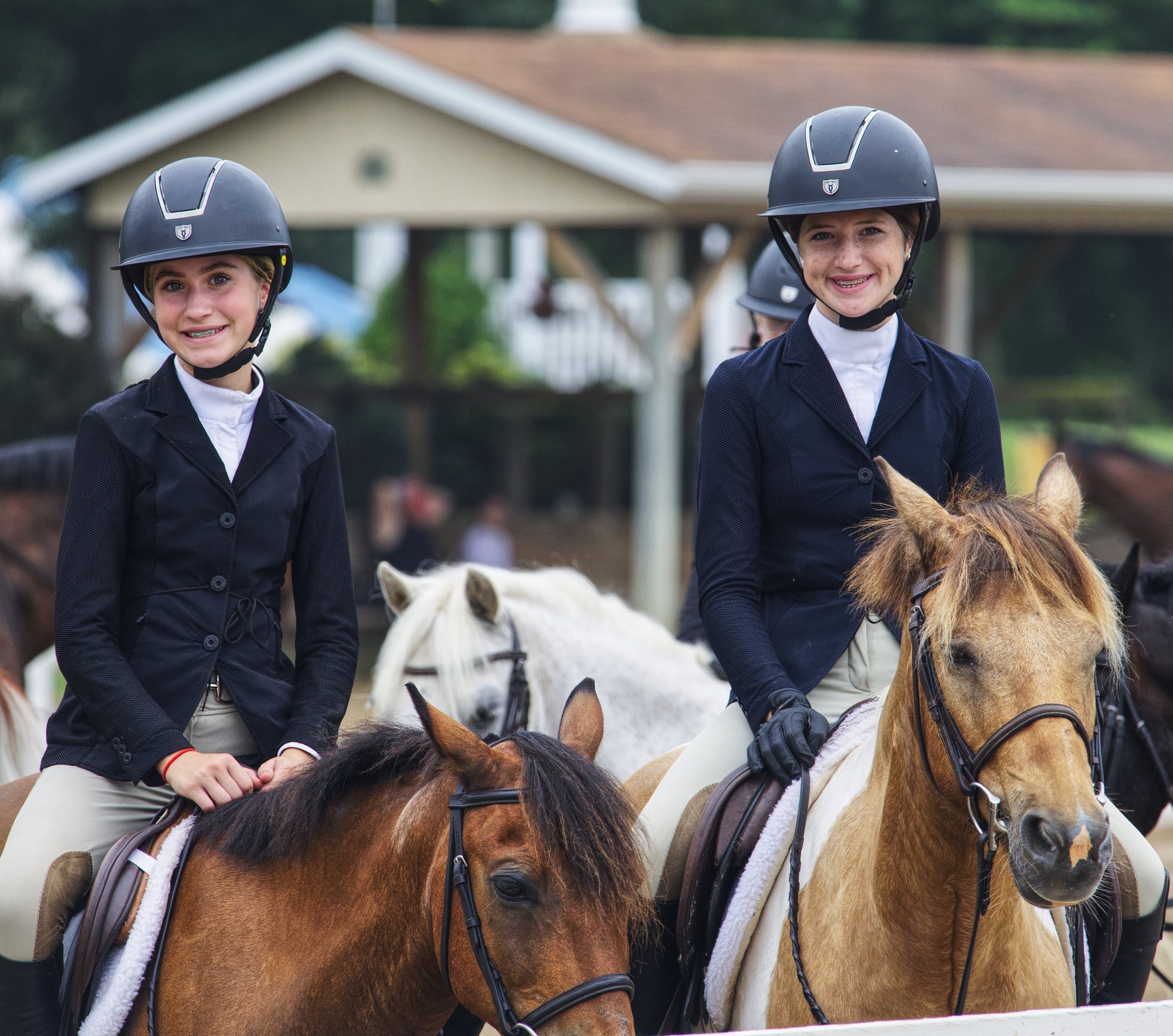 Sadie and Olivia mounted side-by-side at a horse show